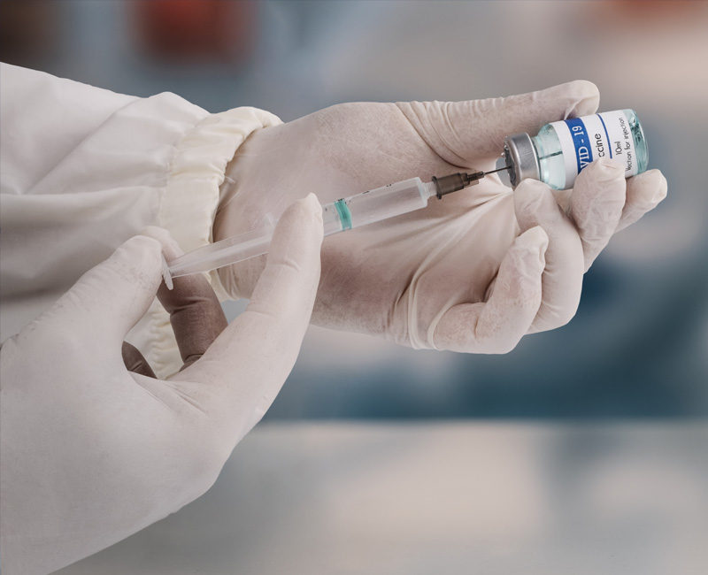 Doctor holding a syringe and a vial of medicine